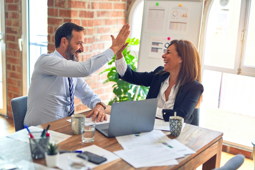 Two business people giving each other a high-five.  